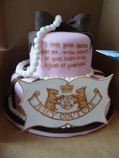 a pink cake with white frosting and two bears on the top, sitting in a box