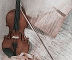 a violin and some sheet music on a bed