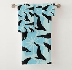 two towels hanging on a towel rack in front of a white wall with black and blue seagulls