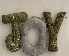 a christmas ornament hanging from the side of a wall next to a sign that says joy