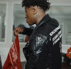 a man with dreadlocks is holding a red and white flag in his hand