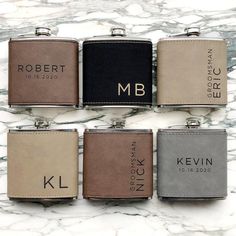 six personalized flasks are lined up on a marble counter