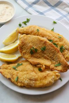 crispy air fryer fish on a plate with lemon wedges