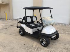 a white and black golf cart parked in front of a building