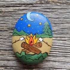 a painted rock with a campfire on it