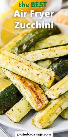 the best air fryer zucchini recipe on a plate with lemon wedges