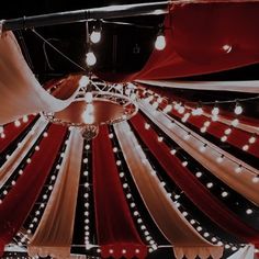 a red and white tent with lights hanging from it's ceiling