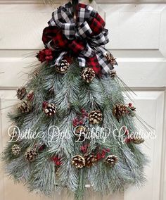 a christmas tree with pine cones and plaid bow