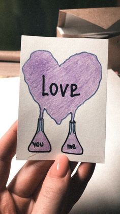 someone holding up a piece of paper with the words love and two flasks