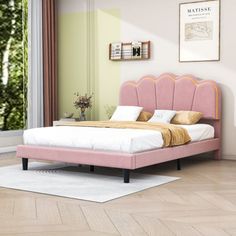 a pink bed sitting in a bedroom on top of a hard wood floor next to a window