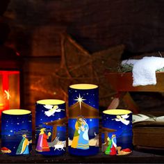 candles are lit in front of a nativity scene