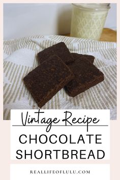 three pieces of chocolate shortbread sitting on top of a towel next to a glass of milk