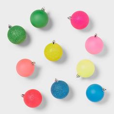 six different colored balls are arranged in a circle on a white surface, with one ball hanging from the middle