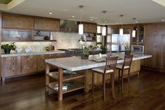 a large kitchen with wooden cabinets and an island in front of the stove top oven