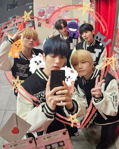 group of young men standing in front of a mirror taking a selfie with their cell phone