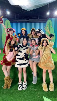 a group of women dressed in animal costumes posing for a photo on the green carpet