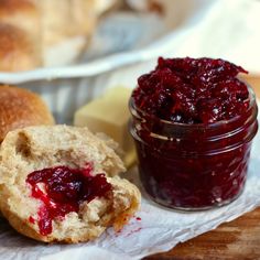 cranberry sauce in a glass jar next to bread