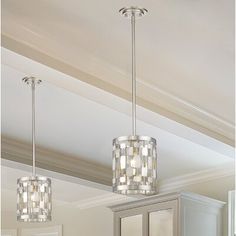 two lights are hanging from the ceiling above a cabinet in a room with white walls