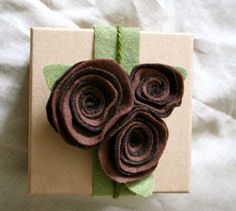 a close up of a flower on a piece of paper with some green and brown ribbon