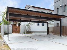 an outdoor covered patio area in front of a white building with wood slats on the sides