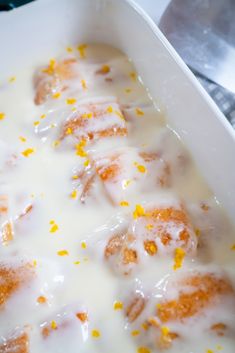 a close up of food in a pan with icing and oranges on it