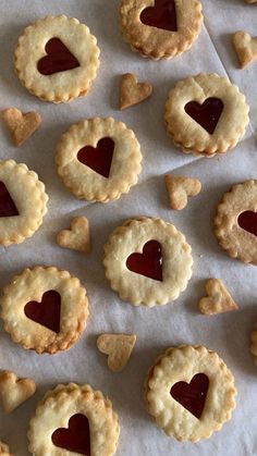 heart shaped cookies are arranged on a sheet of wax paper with hearts in the middle