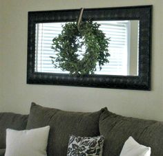 a living room filled with furniture and a wreath hanging on the wall above it's headboard