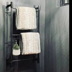 the towel rack is holding two towels and a potted plant