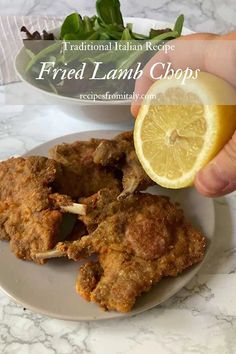 fried lamb chops on a plate with a lemon wedge