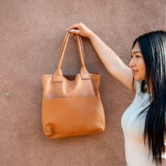 A classic leather tote bag that carries it all—for work and play, at home and while you travel. Featuring a deep, roomy interior for all your daily necessities, a large wall pocket, and thick straps so you can feel confident carrying anything and everything. Premium veg-tanned sheep leather 16" wide and 14" tall Interior wall pocket will fit a 13" laptop Handcrafted and hand-stitched Workwear Bucket Bag With Leather Lining, Everyday Satchel With Leather Handles And Double Handle, Everyday Double Handle Satchel With Leather Handles, Modern Leather-lined Tote Satchel, Minimalist Double Handle Shoulder Bag With Leather Lining, Modern Shoulder Bag With Leather Lining For Everyday Use, Modern Everyday Shoulder Bag With Leather Lining, Everyday Weekender Bag With Double Handle, Leather Lined Satchel Hobo Bag