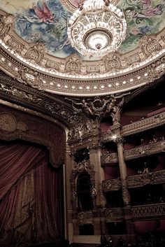 an ornately decorated auditorium with curtains and chandelier