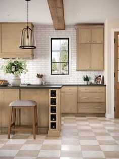 a kitchen that has some stools in the middle of it and a table with two wine bottles on it