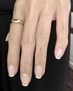 a woman's gold ring with tiny stars on her left hand and the middle finger