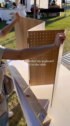 a woman is placing pegboard on top of the table