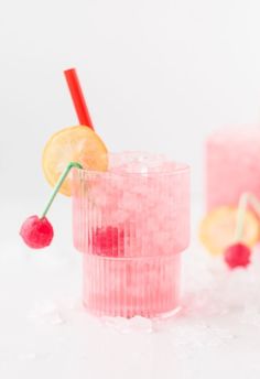 a pink drink with lemon and cherries on the rim