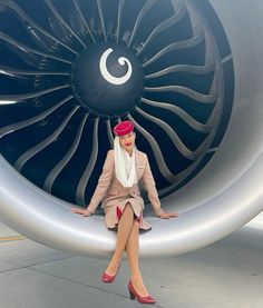 a woman sitting on the side of an airplane engine