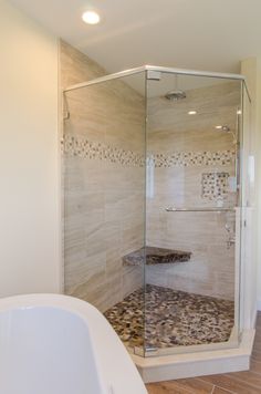 a walk in shower sitting next to a bath tub