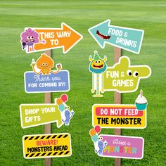 a bunch of signs that are on top of a pole in the grass with some balloons