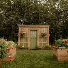 two wooden planters sitting in front of a green door on top of a lush green field