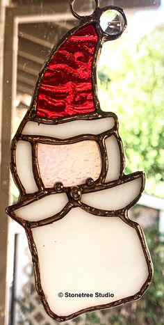 a stained glass christmas ornament hanging from a window