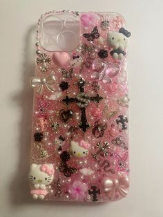 an iphone case with hello kitty and other items on it, all covered in pink glitter