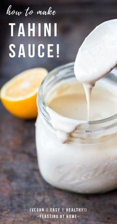 a spoon full of tahini sauce being drizzled over the top of a jar