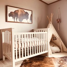 a baby's room with a teepee tent and an animal rug