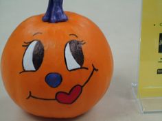 an orange pumpkin with a face painted on it's side and eyes drawn on the top