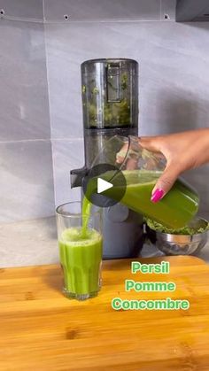 a person pouring green juice into a blender