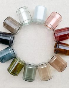 several different colored glass cups arranged in a circle