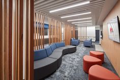 a room with couches, tables and chairs in front of wooden partitions on the wall