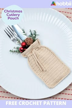 a white plate topped with a crochet christmas cookie and a bag on top of it