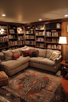 a living room filled with lots of furniture and bookshelves full of books on shelves