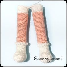 a pair of crocheted leg warmers with pink and white stripes